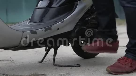 双腿穿红色运动鞋启动一辆旧滑板车视频的预览图
