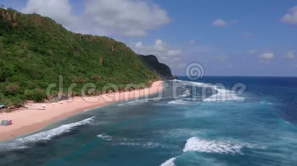 巴厘岛的雨林和恩阳尼扬海滩从沿着海滩线和海浪飞行的无人机进行空中射击视频的预览图
