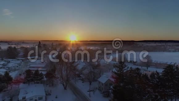 清晨日出的鸟瞰美丽乡村落雪后视频的预览图