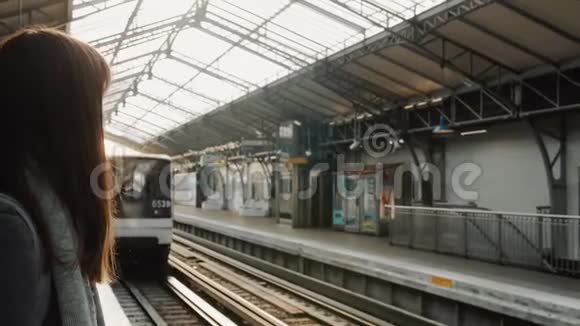 年轻的高加索女人在巴黎火车站等地铁列车火车正向站台缓慢行驶视频的预览图