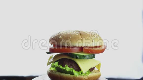 女性手从盘子里拿了一个大汉堡大的多汁汉堡有牛肉切新鲜蔬菜和奶油奶酪手视频的预览图