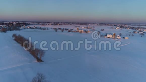 清晨日出的鸟瞰美丽乡村落雪后视频的预览图