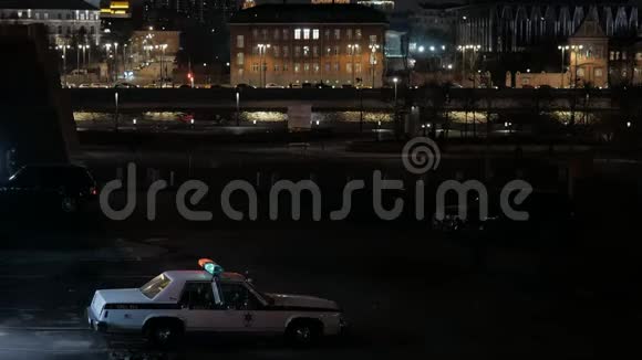 一辆开着闪光灯的旧警车停在桥附近视频的预览图