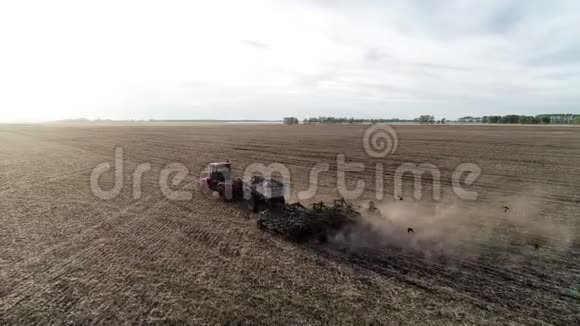 农业机械对农田农田的工业耕作的鸟瞰视频的预览图