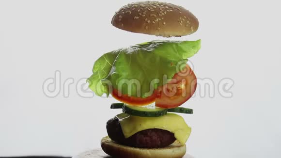 汉堡的组成部分大的多汁汉堡有牛肉切新鲜蔬菜和奶油奶酪快餐高热量食品视频的预览图