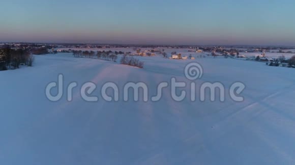 清晨日出的鸟瞰美丽乡村落雪后视频的预览图