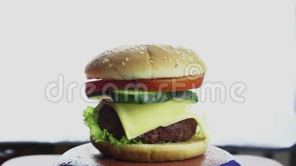 女性手从盘子里拿了一个大汉堡大的多汁汉堡有牛肉切新鲜蔬菜和奶油奶酪手视频的预览图