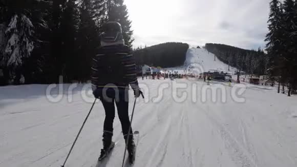 滑雪场滑雪和业余滑雪者的新手女孩滑下滑雪坡视频的预览图