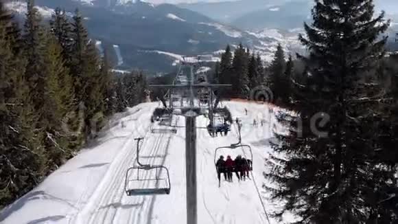 在山顶滑雪者的带领下滑雪者飞过滑雪台和雪滑坡视频的预览图