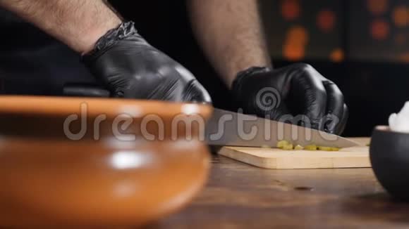 美味的菜肴厨师在木切割板上切片原料并在碗中混合慢动作厨师烹饪视频的预览图