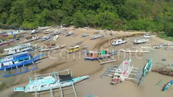 无人机在泻湖的蔚蓝水面上观看菲律宾传统船只蓝色海湾海景视频的预览图