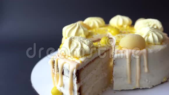 女人的手在深色背景上用黄色奶油切蛋糕白蛋糕俯视图视频的预览图