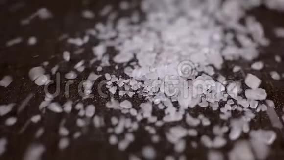 白色海盐的晶体落在木桌上视频的预览图