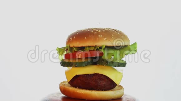 大的多汁汉堡有牛肉切新鲜蔬菜和融化的奶酪视频的预览图