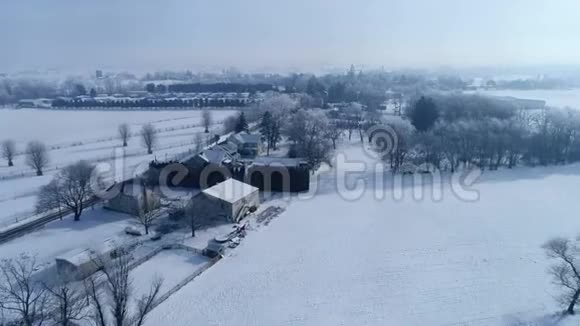 清晨日出的鸟瞰美丽乡村落雪后视频的预览图