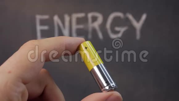 一名男子在能源旁边手持AA电池的特写镜头视频的预览图