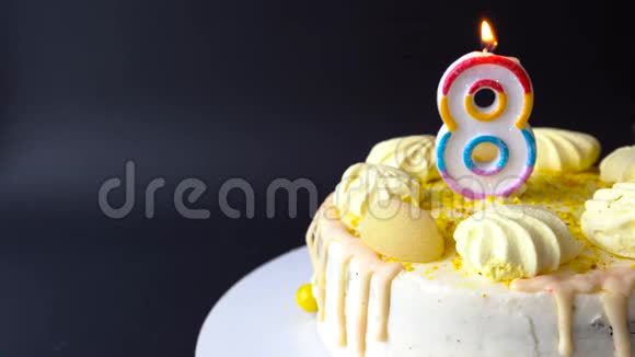8号蜡烛在美味的蛋糕在黑暗的背景蛋糕生日快乐视频的预览图