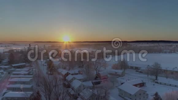 清晨日出的鸟瞰美丽乡村落雪后视频的预览图