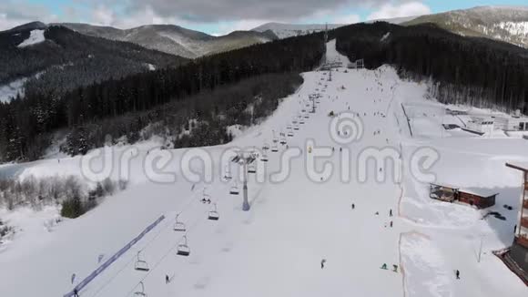 雪山滑雪场上有滑雪者和滑雪升降机的空中滑雪斜坡视频的预览图