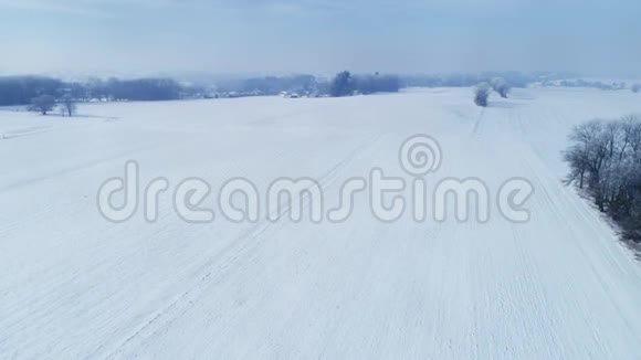 清晨日出的鸟瞰美丽乡村落雪后视频的预览图