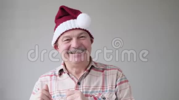 快乐的西班牙裔老人戴着圣诞红帽子跳舞为节日而高兴视频的预览图
