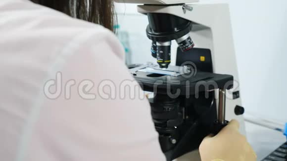 自动科学实验室显微镜的特写镜头在准备好的幻灯片上检查生物样品背面视图视频的预览图