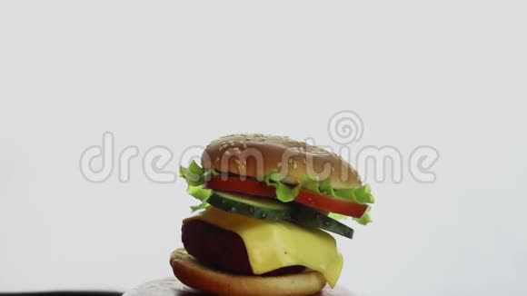 厨师手在一道菜上调整一个大汉堡的配料大的多汁汉堡有牛肉片新鲜蔬菜和奶油视频的预览图
