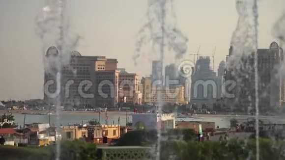 模糊的视野一个城市的慢动作喷泉在前景拍摄于卡塔尔多哈阳光明媚的一天视频的预览图