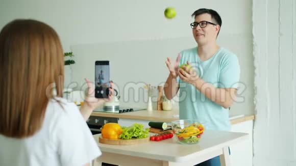 一个男人在偷苹果然后在女人拍照的时候摆姿势视频的预览图
