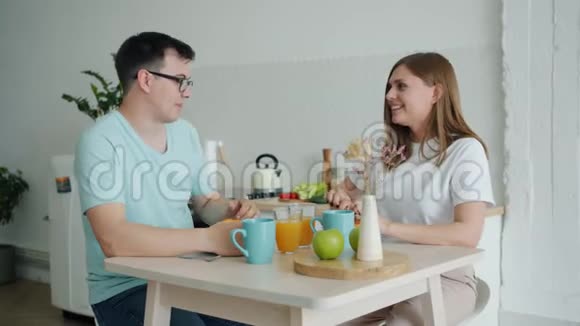 男人和女人一起吃羊角面包一起坐在餐桌旁聊天视频的预览图