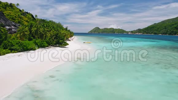 在热带异国海滩上孤独的旅游船的空中4k镜头完美的白沙和蓝绿色海洋泻湖视频的预览图