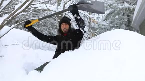 雪堆里的人用铲子翻雪视频的预览图