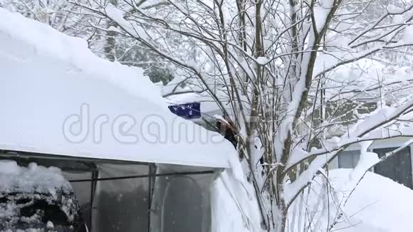 在冬天的一幕中人们从车上的雨篷上清除积雪视频的预览图