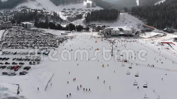 在滑雪场滑雪电梯附近的滑雪坡上看到很多人滑雪的空中景色视频的预览图