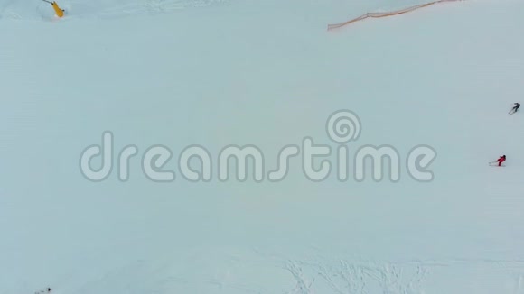 滑雪者在冬季滑雪胜地雪雪滑雪坡上滑下的俯视图视频的预览图