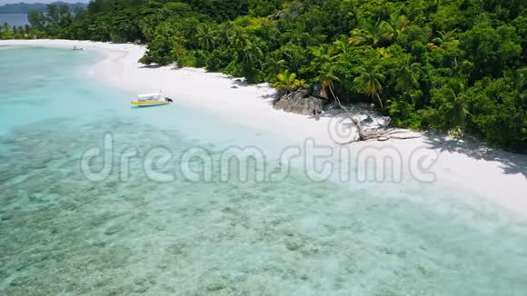 空中4k镜头孤舟停泊在完美的白沙异国海滩与绿松石泻湖视频的预览图