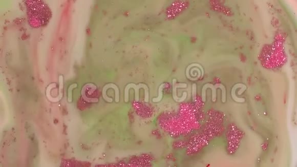粉红色的火花漂浮在绿色液体上视频的预览图