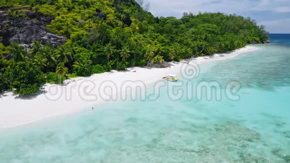 带着孤独游客的热带异国海滩空中4k镜头完美的白沙和绿松石泻湖水视频的预览图