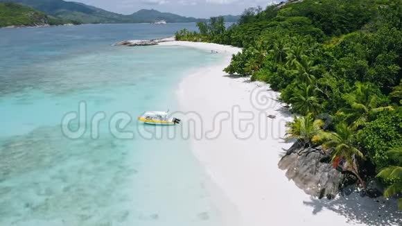 空中4k的热带异国海滩的镜头孤舟停泊在完美的白色沙滩上有绿松石泻湖视频的预览图