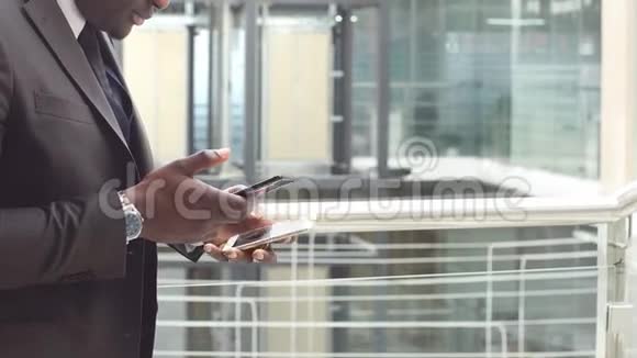 非裔美国商人用两部智能手机检查商务邮件视频的预览图