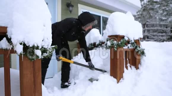女人从入口铲雪到冬天的小屋视频的预览图