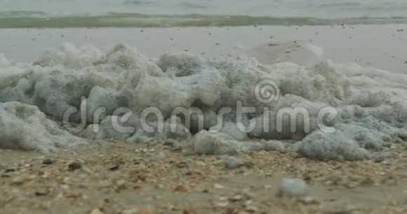 海岸上被污染的海洋泡沫有毒化学物质污染脏海概念视频的预览图