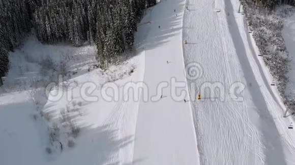 滑雪者在滑雪胜地滑雪升降机附近的高空俯瞰滑雪斜坡Bukvel视频的预览图