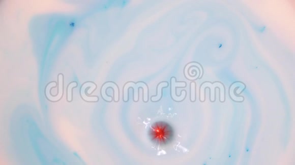 将红橙色颜料滴入白色蓝色液体中视频的预览图