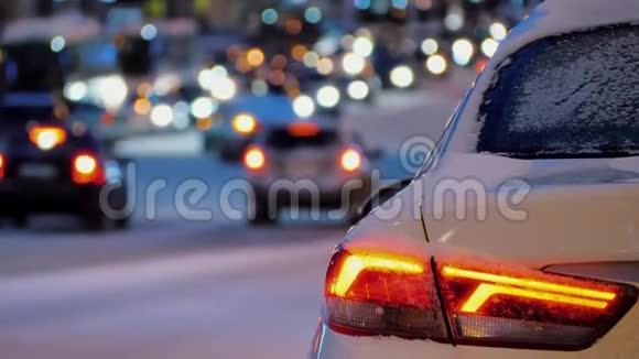 停在城市汽车交通背景下的汽车后部汽车尾灯开启视频的预览图