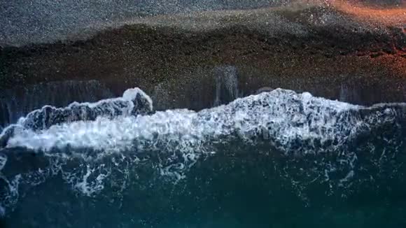 鸟瞰美丽的海波缓缓漫过沙滩日落的黄金时刻美丽的波浪视频的预览图