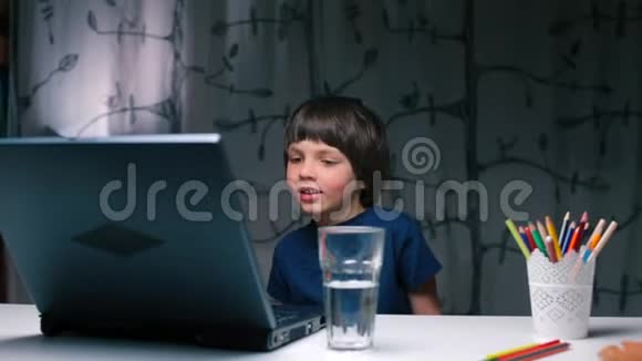 一个男孩在笔记本电脑上倒了一杯水视频的预览图