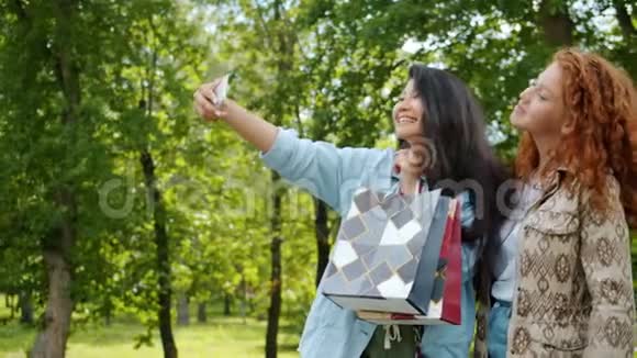 快乐的青少年用智能手机用购物袋自拍视频的预览图