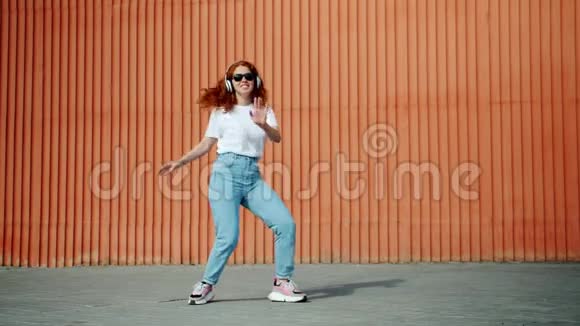年轻女士戴着耳机和太阳镜在户外跳舞视频的预览图