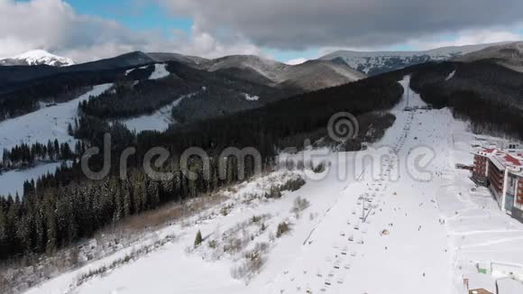 在滑雪场滑雪电梯附近的滑雪坡上看到很多人滑雪的空中景色视频的预览图